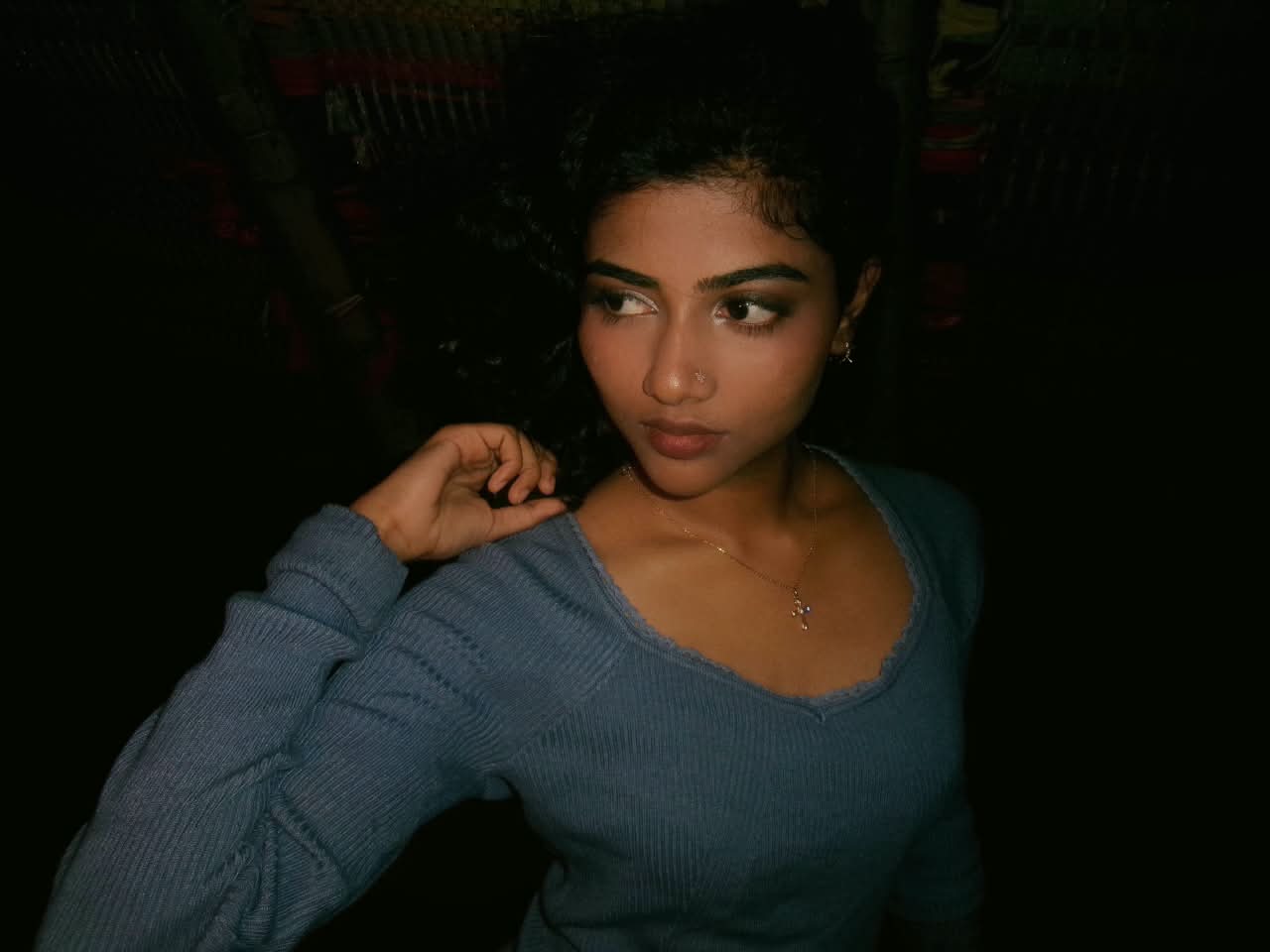 Portrait of a girl in a blue sweater glancing over her shoulder